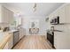 Bright kitchen features white cabinets, stainless steel appliances, marble countertops, and wood floors at 8004 Mill Bluff Ct, Raleigh, NC 27616