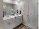 Bright bathroom featuring a double vanity with white countertop and cabinets, accented by sleek fixtures and wood-look flooring at 805 Ottawa Dr, Garner, NC 27529