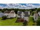 An aerial view of the home's backyard featuring a deck, green grass, trees, and other homes in the neighborhood at 1003 Southshore Pkwy, Durham, NC 27703