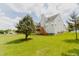 Lush backyard featuring a deck, green grass and a large tree providing shade and curb appeal at 1003 Southshore Pkwy, Durham, NC 27703