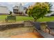 Lush backyard with a tiered landscape, mature tree, an outdoor bench, and a deck with screened porch at 1003 Southshore Pkwy, Durham, NC 27703