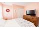 Comfortable bedroom with a wooden dresser, TV, closet, and soothing color scheme at 1003 Southshore Pkwy, Durham, NC 27703