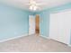 Bright bedroom featuring light blue walls, a ceiling fan, and a double door closet at 1003 Southshore Pkwy, Durham, NC 27703