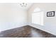 Dining room featuring hardwood floors, wainscoting, chandelier, and a large window at 1003 Southshore Pkwy, Durham, NC 27703