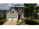 Charming home with a two-car garage, stone accents, a manicured lawn, and beautiful landscaping at 1003 Southshore Pkwy, Durham, NC 27703