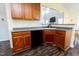 Close-up view of kitchen sink with wood cabinets and dark brown flooring at 1003 Southshore Pkwy, Durham, NC 27703