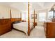 Spacious main bedroom with a four-poster bed, ceiling fan, and natural light, creating a relaxing retreat at 1003 Southshore Pkwy, Durham, NC 27703
