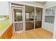 Charming screened porch with wooden floors and railing, offering a cozy view of the outdoors at 1003 Southshore Pkwy, Durham, NC 27703