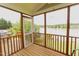 Inviting screened porch with wood floors, offering a serene view of the lake and a grill at 1003 Southshore Pkwy, Durham, NC 27703