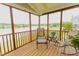 Relaxing screened porch with furniture, providing a tranquil view of the lake and lush greenery at 1003 Southshore Pkwy, Durham, NC 27703