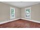 Comfortable bedroom showcasing hardwood floors, neutral paint, and two large windows for ample natural light at 1007 Grace Ave, Burlington, NC 27217
