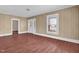 Cozy living room featuring beautiful floors, a large window with blinds, and an open doorway to another room at 1007 Grace Ave, Burlington, NC 27217