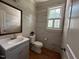 Cozy half bath with wood-look tile, decorative mirror, and window at 1021 Golden Star Way, Wake Forest, NC 27587
