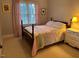 Cozy bedroom with decorative quilt, wood floors, and pink curtains at 1021 Golden Star Way, Wake Forest, NC 27587