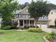 Charming brick home featuring a manicured lawn, covered front porch, and a two-car attached garage at 1021 Golden Star Way, Wake Forest, NC 27587