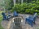 Backyard fire pit surrounded by chairs and a stone wall, nestled amongst mature trees at 1021 Golden Star Way, Wake Forest, NC 27587