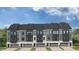 Newly constructed townhomes with gray siding, stylish black trim, and individual one car garages at 10514 Pleasant Branch Dr # 35, Raleigh, NC 27614