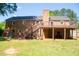 Expansive backyard with a deck, play set, brick siding, and stairs that lead to the yard at 106 Chariot Dr, Sanford, NC 27330