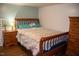Bedroom with wooden bed frame, matching nightstand, dresser, and hardwood floors at 106 Chariot Dr, Sanford, NC 27330