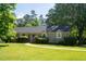 Traditional home featuring a manicured lawn and beautiful green trees at 106 Chariot Dr, Sanford, NC 27330