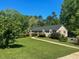Charming home features a manicured lawn, lush landscaping, and inviting walkway at 106 Chariot Dr, Sanford, NC 27330