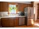 Charming kitchen featuring stainless steel appliances, a window with plants and hardwood floors at 106 Chariot Dr, Sanford, NC 27330