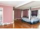 Large bedroom featuring wood floors, pink walls, and access to bathroom at 110 W Parker St, Smithfield, NC 27577