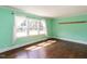 Bright bedroom with hardwood floors, large windows, and white curtains at 110 W Parker St, Smithfield, NC 27577