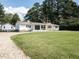 Charming single-story home with a gravel driveway and covered patio, perfect for relaxing outdoors at 110 W Parker St, Smithfield, NC 27577