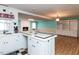 Bright kitchen with white cabinets, black accents, and an adjoining living area with a brick fireplace at 110 W Parker St, Smithfield, NC 27577