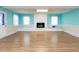 Bright living room with a white brick fireplace, laminate floors, and a large window at 110 W Parker St, Smithfield, NC 27577