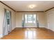A spacious living room with hardwood floors and large windows with sheer curtains at 110 W Parker St, Smithfield, NC 27577