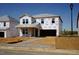 Unfinished two-story home exterior with a two-car garage and covered porch, showcasing its potential at 1116 Landen Creek Ln, Zebulon, NC 27597
