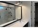 Modern bathroom vanity with quartz countertop, black faucet and mirror reflecting glass shower at 118 Sanderway Dr, Chapel Hill, NC 27516