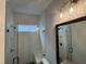 Modern bathroom features a glass shower, window, and vanity mirror with decorative lighting fixture at 118 Sanderway Dr, Chapel Hill, NC 27516