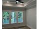 Bright bedroom featuring three large windows offering scenic views of the lush greenery at 118 Sanderway Dr, Chapel Hill, NC 27516
