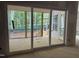 View from the living room, sliding glass doors lead to a wooden screened porch and wooded backyard at 118 Sanderway Dr, Chapel Hill, NC 27516