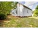 Backyard view of a white two-story home surrounded by lush greenery and a well-maintained lawn at 120 Hatchet Creek Ct Ct, Morrisville, NC 27560