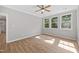 Bright, empty bedroom with three sunny windows and a ceiling fan offering comfortable living space at 120 Hatchet Creek Ct Ct, Morrisville, NC 27560