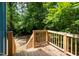View of the wooden back porch with green foliage in the background at 1402 Robinhood Rd, Durham, NC 27701