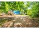A wide backyard with a home and deck, partially shaded by large trees at 1402 Robinhood Rd, Durham, NC 27701
