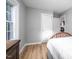 Neutral bedroom with bright window, wood laminate flooring, and classic white door and trim at 1402 Robinhood Rd, Durham, NC 27701