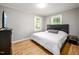 Relaxing bedroom features two windows, hard surface floors, and a modern bed and side table at 1402 Robinhood Rd, Durham, NC 27701
