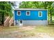 Exterior shot showing the back of a blue house with a staircase to the back door at 1402 Robinhood Rd, Durham, NC 27701