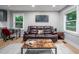 Comfortable living room features leather seating, bright windows, and modern décor at 1402 Robinhood Rd, Durham, NC 27701