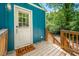 Teal home with cozy covered porch and stairs leading to a door with a welcoming 'hello' mat at 1402 Robinhood Rd, Durham, NC 27701