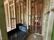 Bathroom under construction, featuring a shower pan with new fixtures and exposed wood framing at 1521 1/2 Sunrise Ave, Raleigh, NC 27608