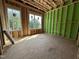 Bedroom under construction, featuring exposed framing, green sheathing, and new windows at 1521 1/2 Sunrise Ave, Raleigh, NC 27608