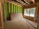 Unfinished bedroom featuring stud framing, exterior sheathing, and window overlooking the neighborhood at 1523 Sunrise Ave, Raleigh, NC 27608
