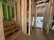 Unfinished entryway with stud framing, stairs, and exterior sheathing at 1523 Sunrise Ave, Raleigh, NC 27608